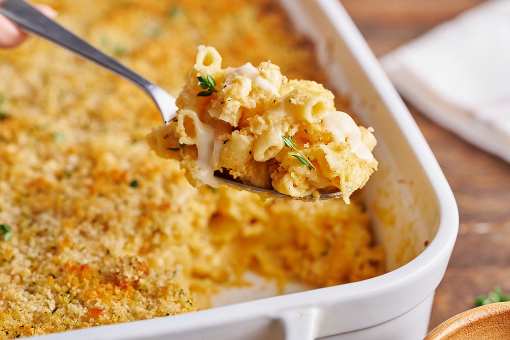 macaroni and cheese recipe being served with a large serving spoon