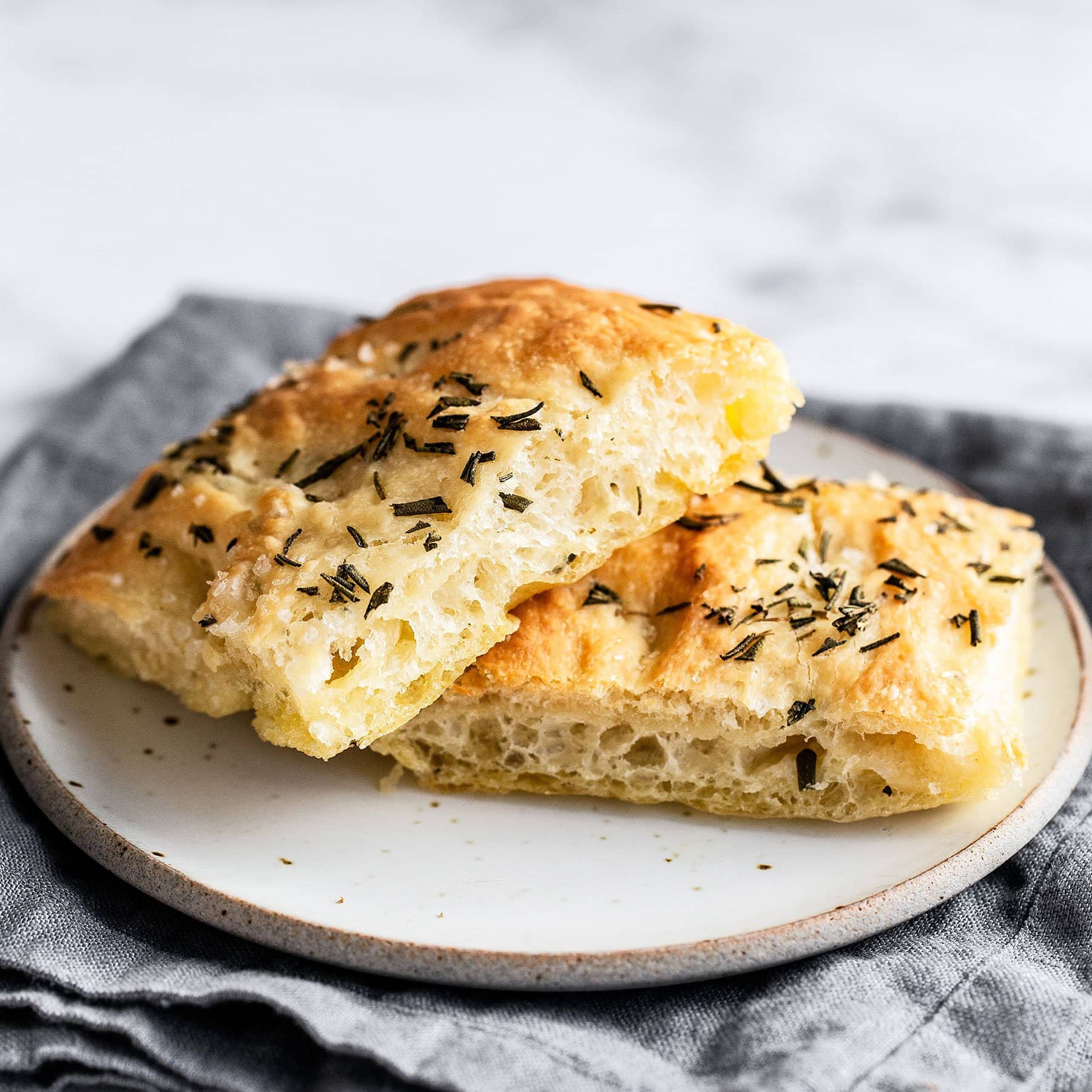 Two slices of rosemary focaccia bread on a plate