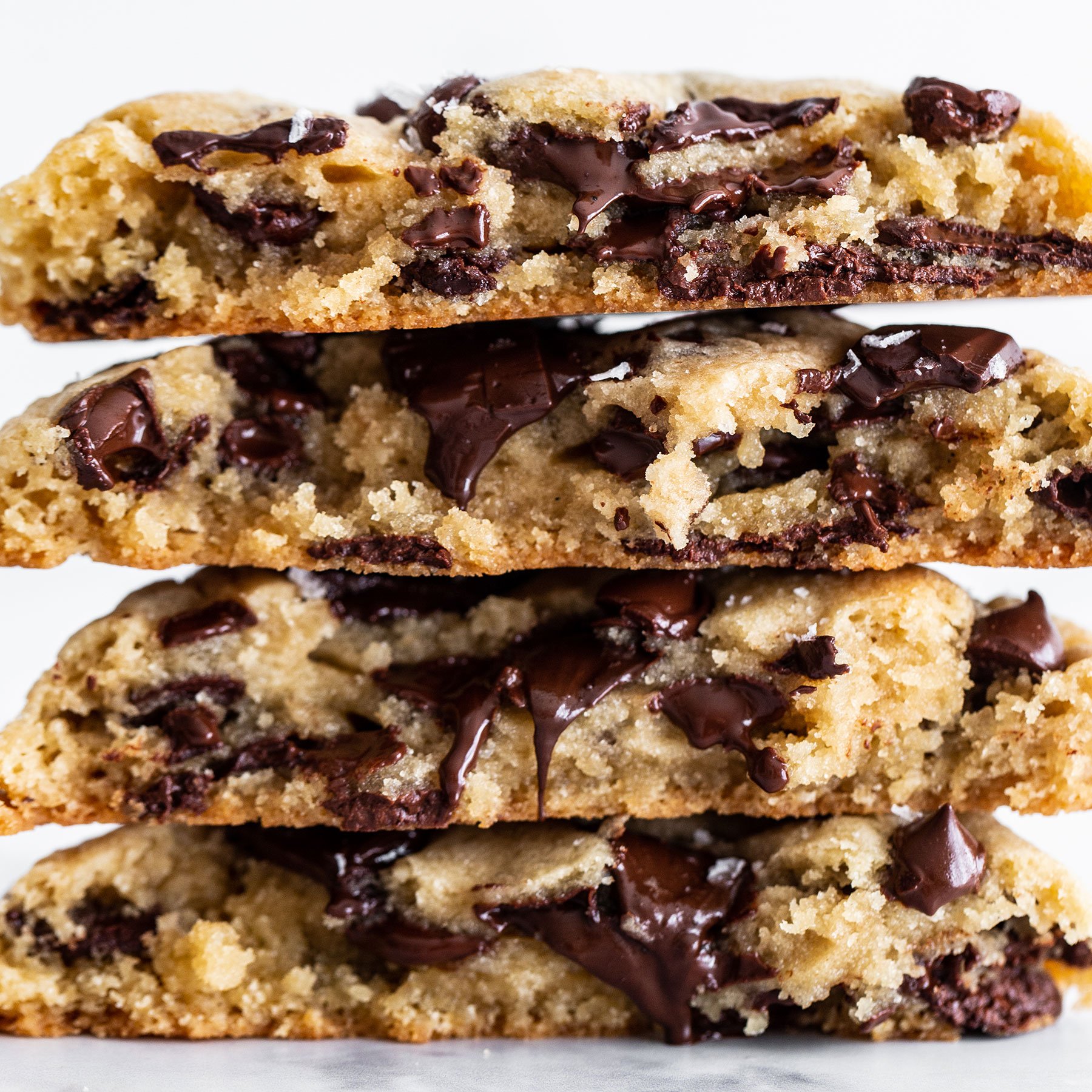 four giant, thick, gooey chocolate chip cookies stacked high