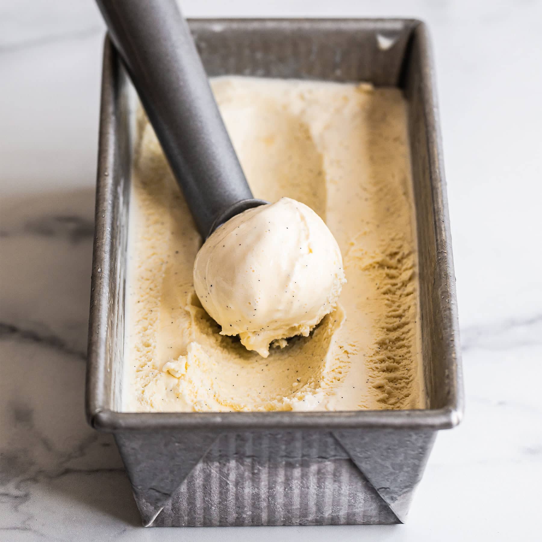 homemade custard based french vanilla ice cream recipe in an ice cream tin
