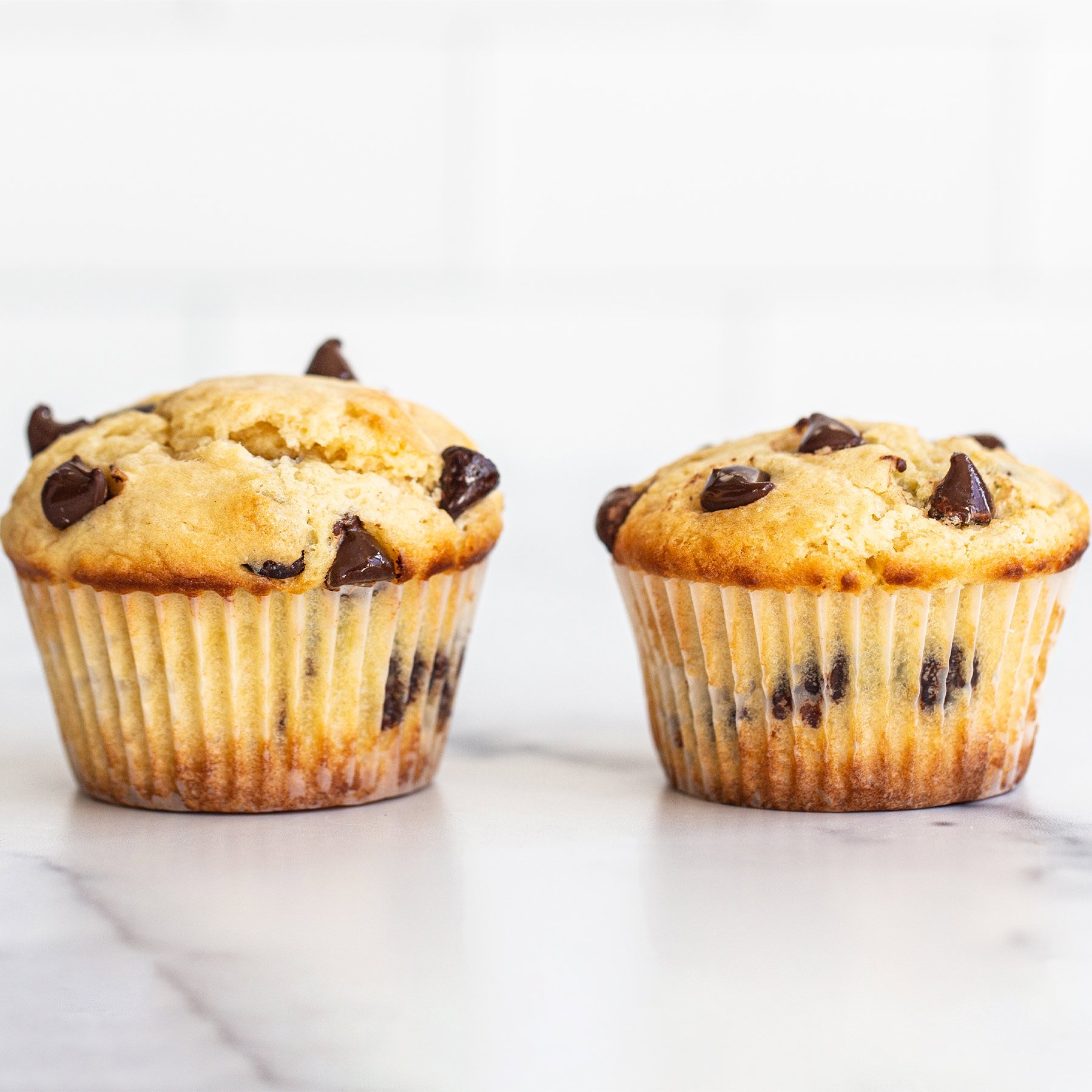 side by side comparison of muffins - one short and one super tall, using my tips!