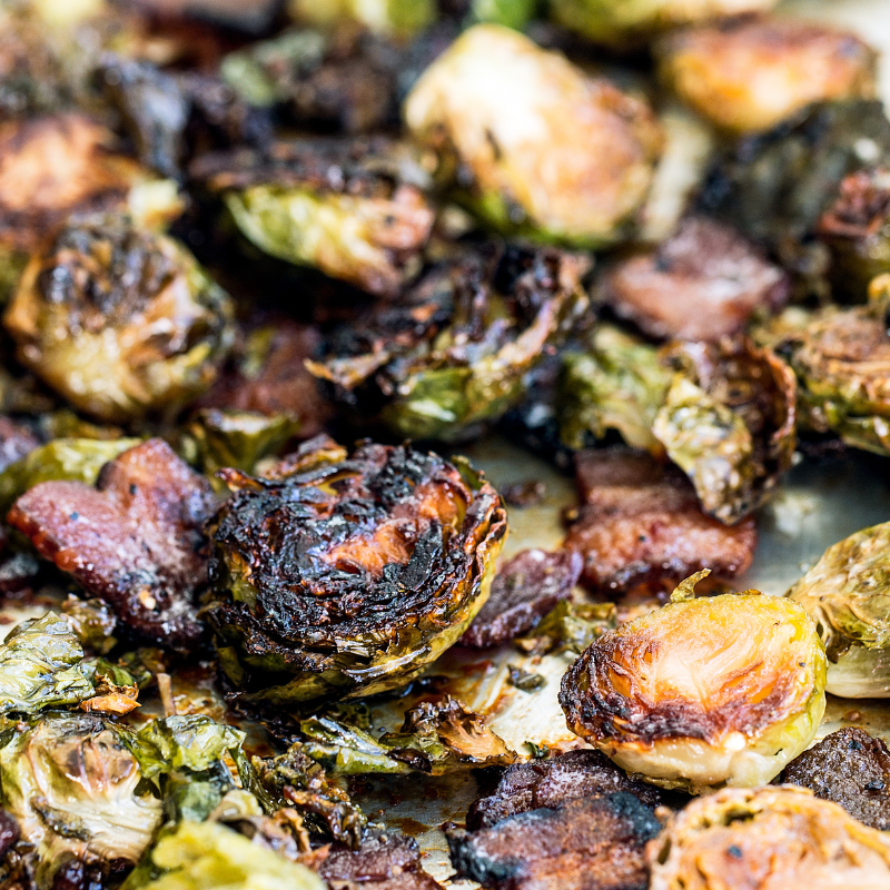 caramelized Brussels sprouts on a sheet pan with bits of crispy bacon.