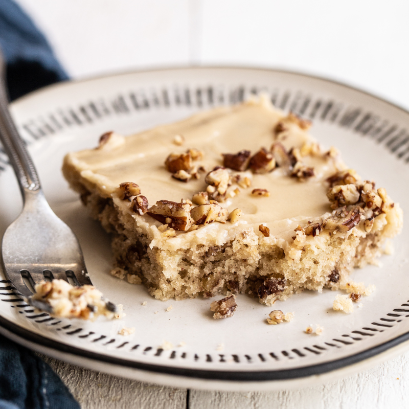 a slice of sheet cake topped with buttery pecans and a brown sugar glaze